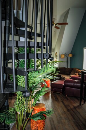 A staircase with black railings, a wooden floor, and a ceiling fan. - Lake Fun! ADK Home Base: Family Friendly 2BR+Loft (Warrensburg)