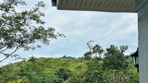 A view from a balcony overlooking a lush, green hillside with dense vegetation. - The Green Horizon Villa Chaweng Hill (Koh Samui)
