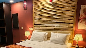 A hotel room with a large bed, two bedside lamps, a ceiling fan, and a wooden headboard. - Rara HM (Hulhumale)
