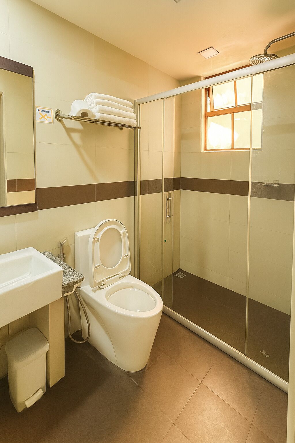 A bathroom with a toilet, sink, and shower.