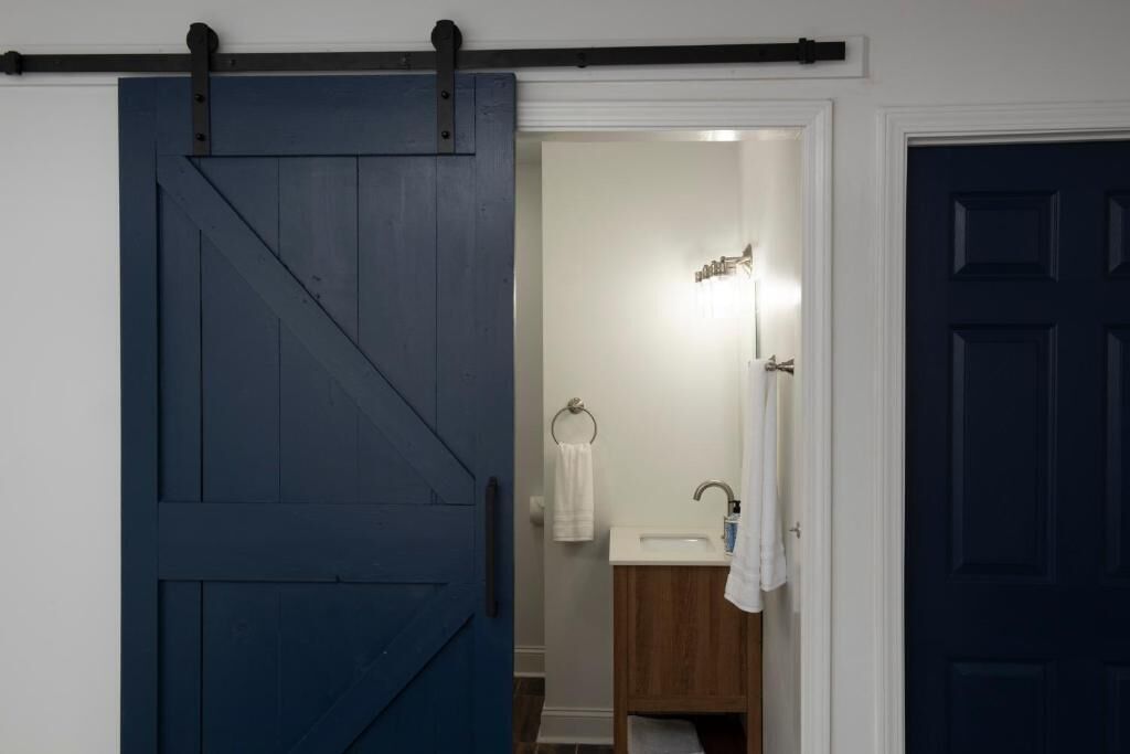 A bathroom with a white sink, a wooden cabinet, and a towel hanging on the wall.