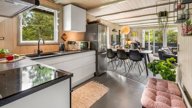 A modern kitchen with a central island, a dining area with chairs, and a cozy seating area with a polka-dotted ottoman. - "Vilhelm" - 10km from the sea by Interhome (Oksbøl)