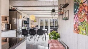 A modern kitchen with a dining area, a colorful abstract painting on the wall, and a bench with cushions. - "Vilhelm" - 10km from the sea by Interhome (Oksbøl)