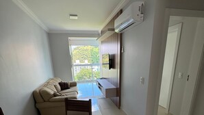 Una sala moderna con un sofá, una mesa de comedor y un televisor.