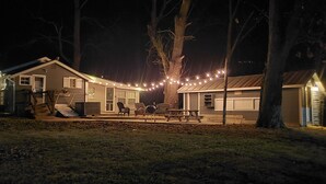 Una casa con porche, mobiliario exterior e iluminación con guirnaldas.