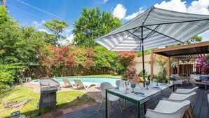 A backyard with a pool, outdoor seating, and a covered patio area. - Peacock Paradise - Pool / Game (Houston)