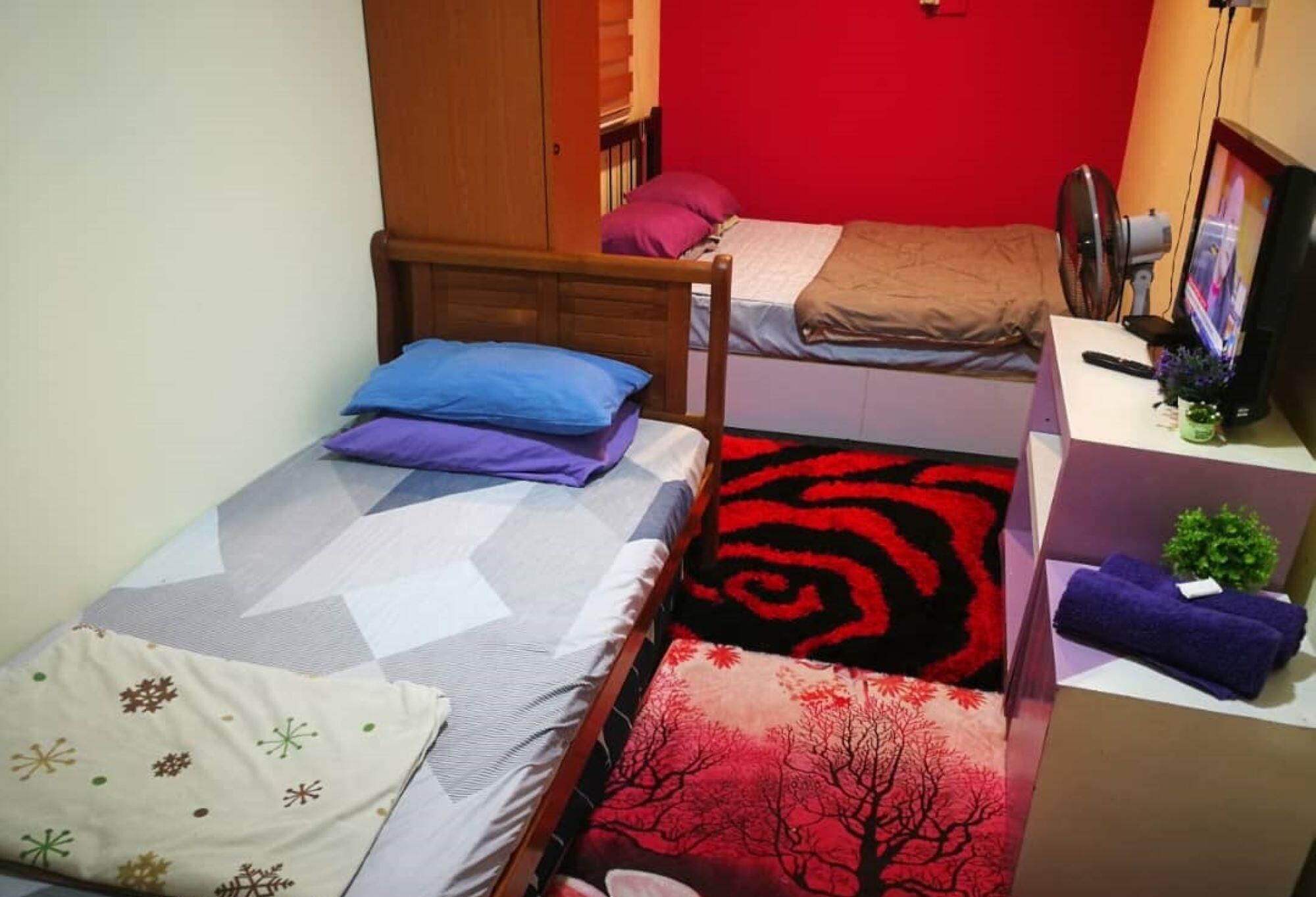 A dormitory room with two beds, a desk, a chair, and a wardrobe.