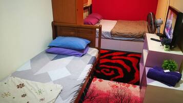A dormitory room with two beds, a desk, a chair, and a wardrobe.