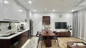 Una cocina moderna con comedor, televisor de pantalla plana y zona de estar con una mesa de centro.