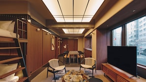 A hotel room with bunk beds, a dining area, a TV, and a large window with a city view. - illi Toas Tokyo-Toranomon (Tokyo)