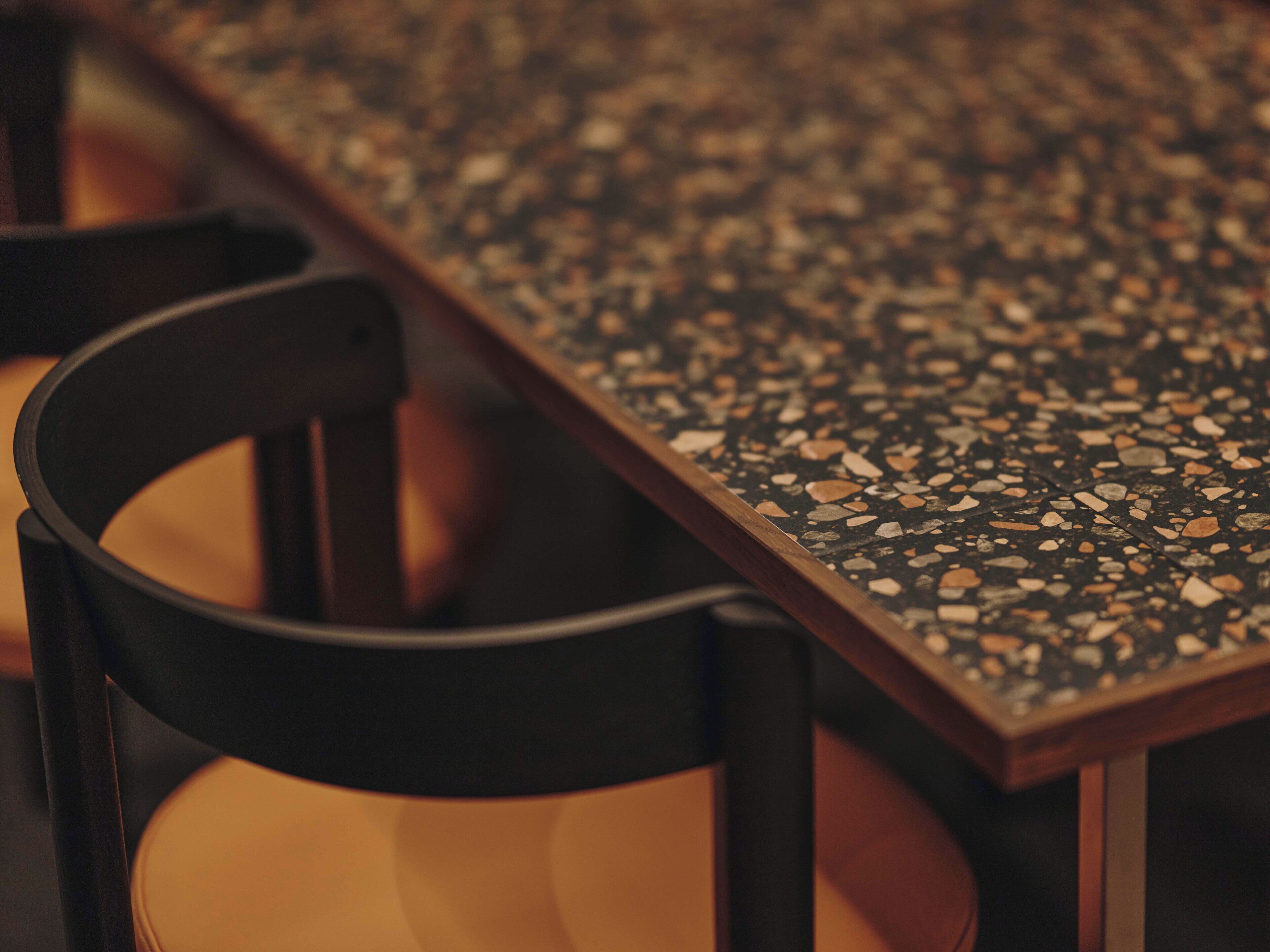 Un primo piano di un pavimento in terrazzo con una sedia e un tavolo.