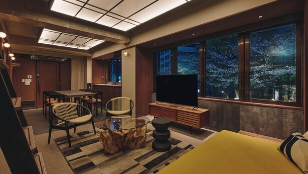 A modern living room with a large TV, wooden furniture, and a view of the city at night. - illi Toas Tokyo-Toranomon (Tokyo)