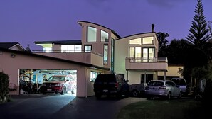 A modern two-story house with a garage and a driveway. - Beachlands Getaway - Room for everyone with a pool and views (Beachlands)