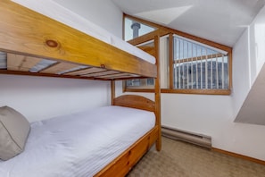 A bunk bed room with a window overlooking a snowy landscape. - Fitzsimmons D - 3BR in the Heart of Whistler Village, Private Sauna (Whistler)