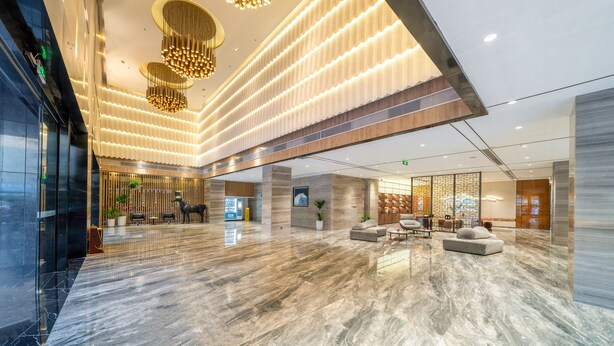 A spacious lobby with a marble floor, modern chandeliers, seating areas, and a reception desk. - ECHENG Liuzhou Wuxing Buxingjie (Liuzhou)