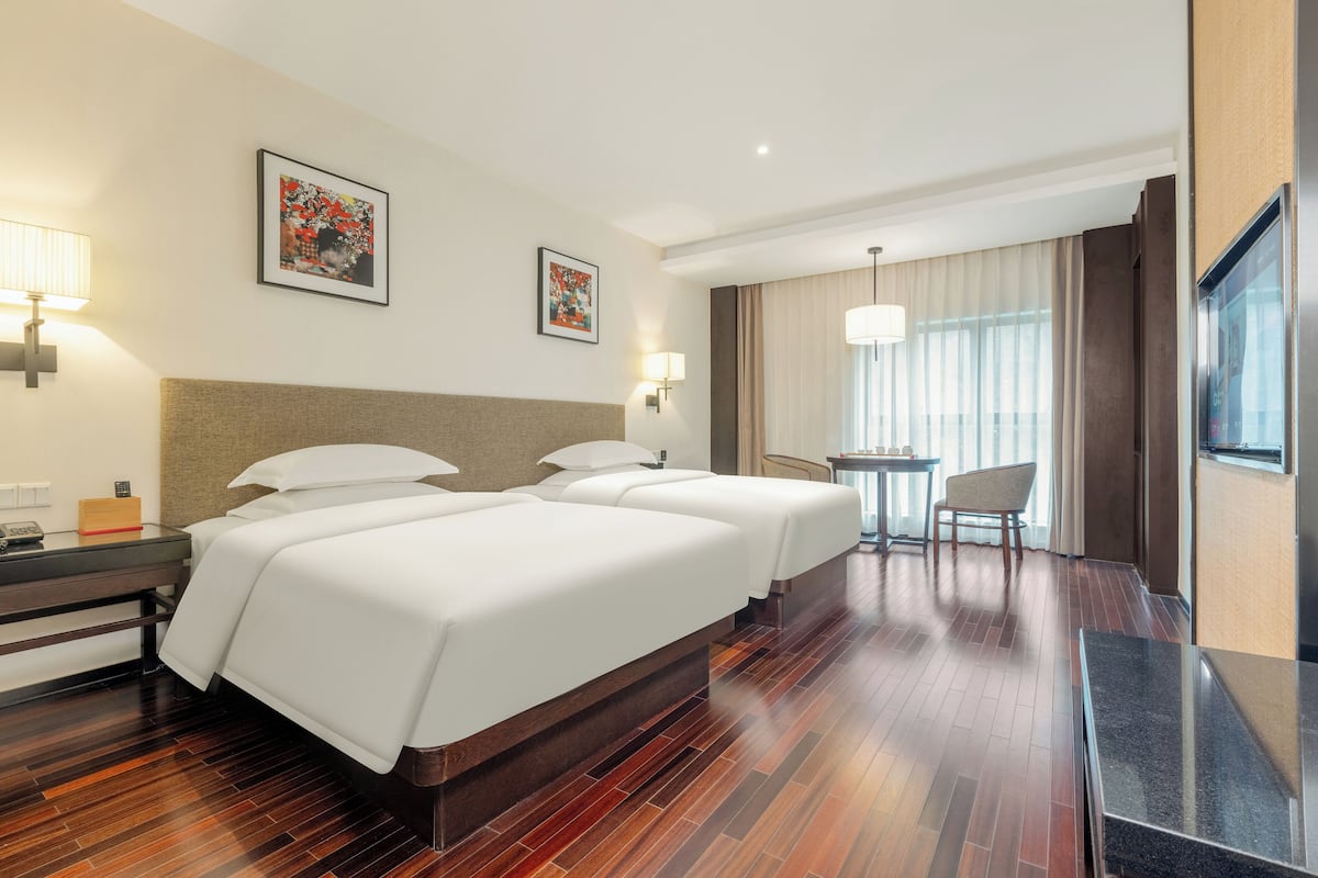 Una habitación de hotel con una cama grande, un escritorio, una silla y una mesita.