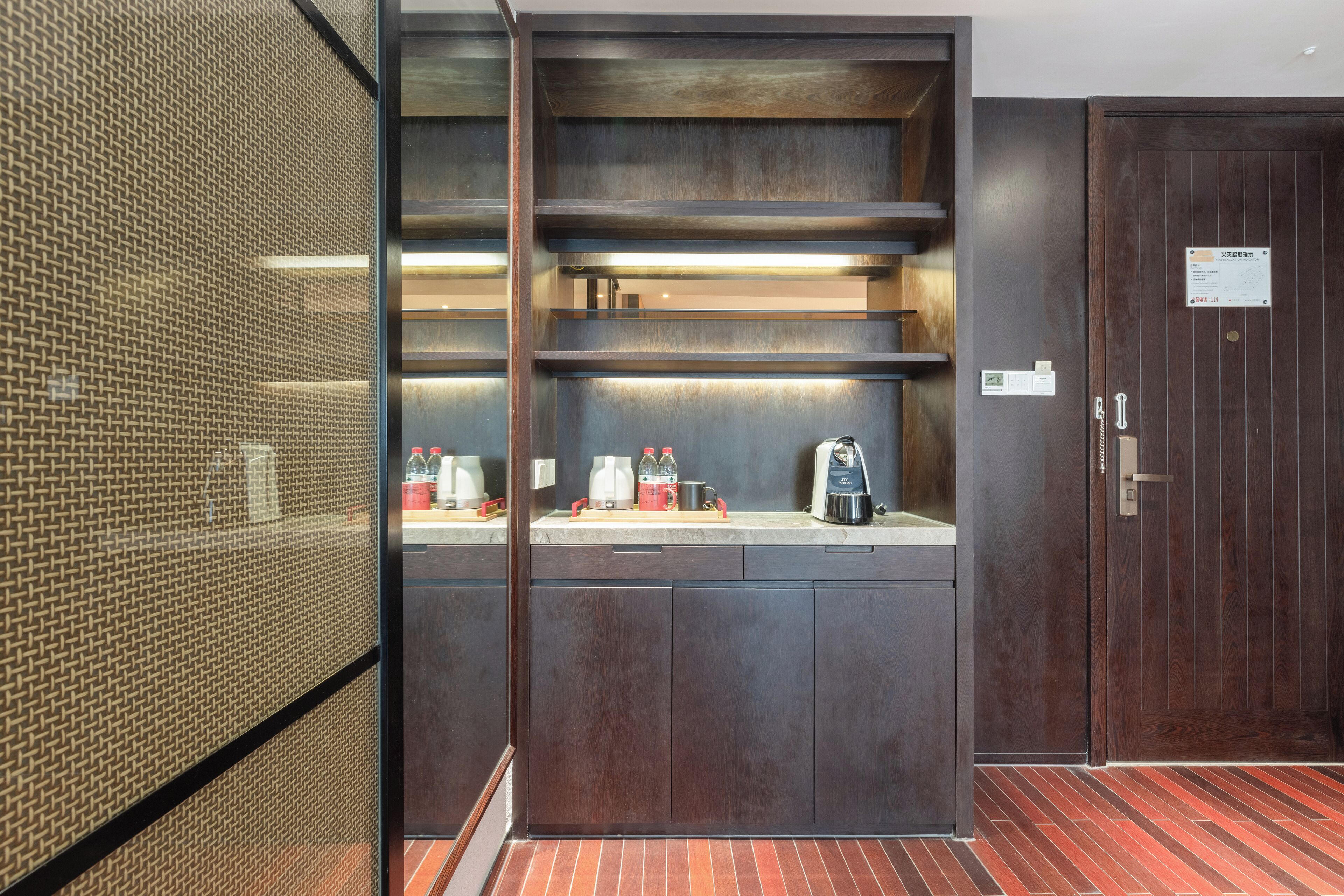 A modern kitchen with built-in shelves, a coffee machine, and a kettle.