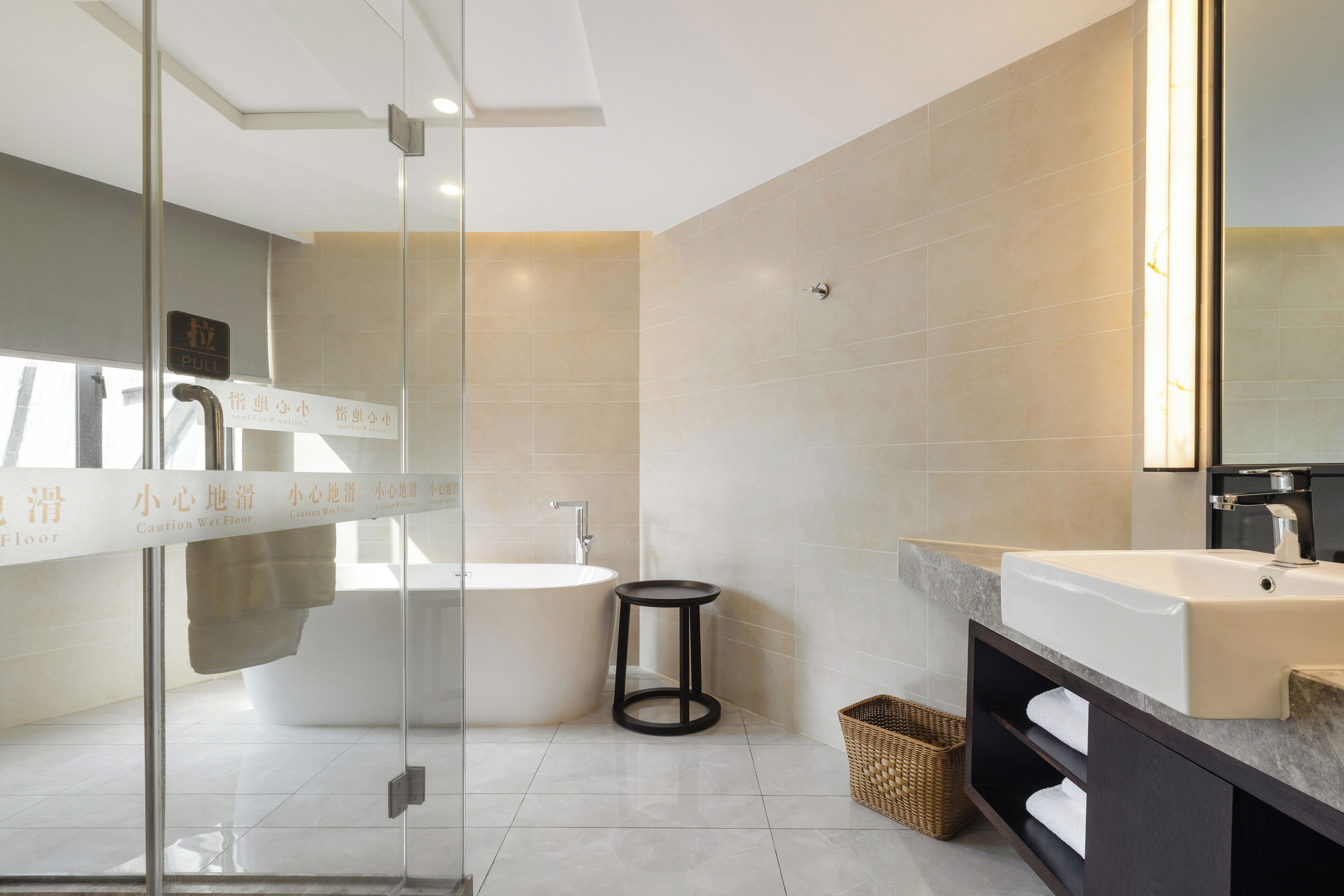A modern bathroom with a glass shower enclosure, a freestanding bathtub, and a vanity with a large mirror.