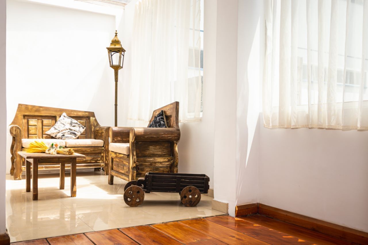A cozy room with a wooden sofa, a small table, a vintage lamp, and a toy train.