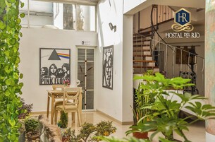 Una habitación con comedor, escalera y vista al exterior.