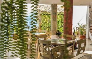 Un restaurante con terraza, sillas y mesas de madera.
