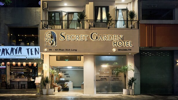The exterior of the Secret Garden Hotel, featuring a modern facade, a visible entrance, and a signboard with the hotel's name and address. - Secret Garden Phan Xich Long (Ho Chi Minh City)