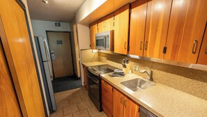 A kitchen with wooden cabinets, a stainless steel sink, a microwave, a stove, and a dishwasher. - Ski-in/ski-out unit for 4 people @Snowbird for New Year's week, 12/27-1/3 (Snowbird)