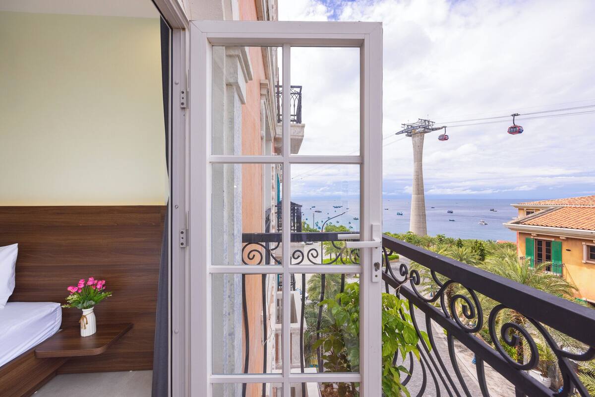 A balcony with a view of the sea and a cable car.