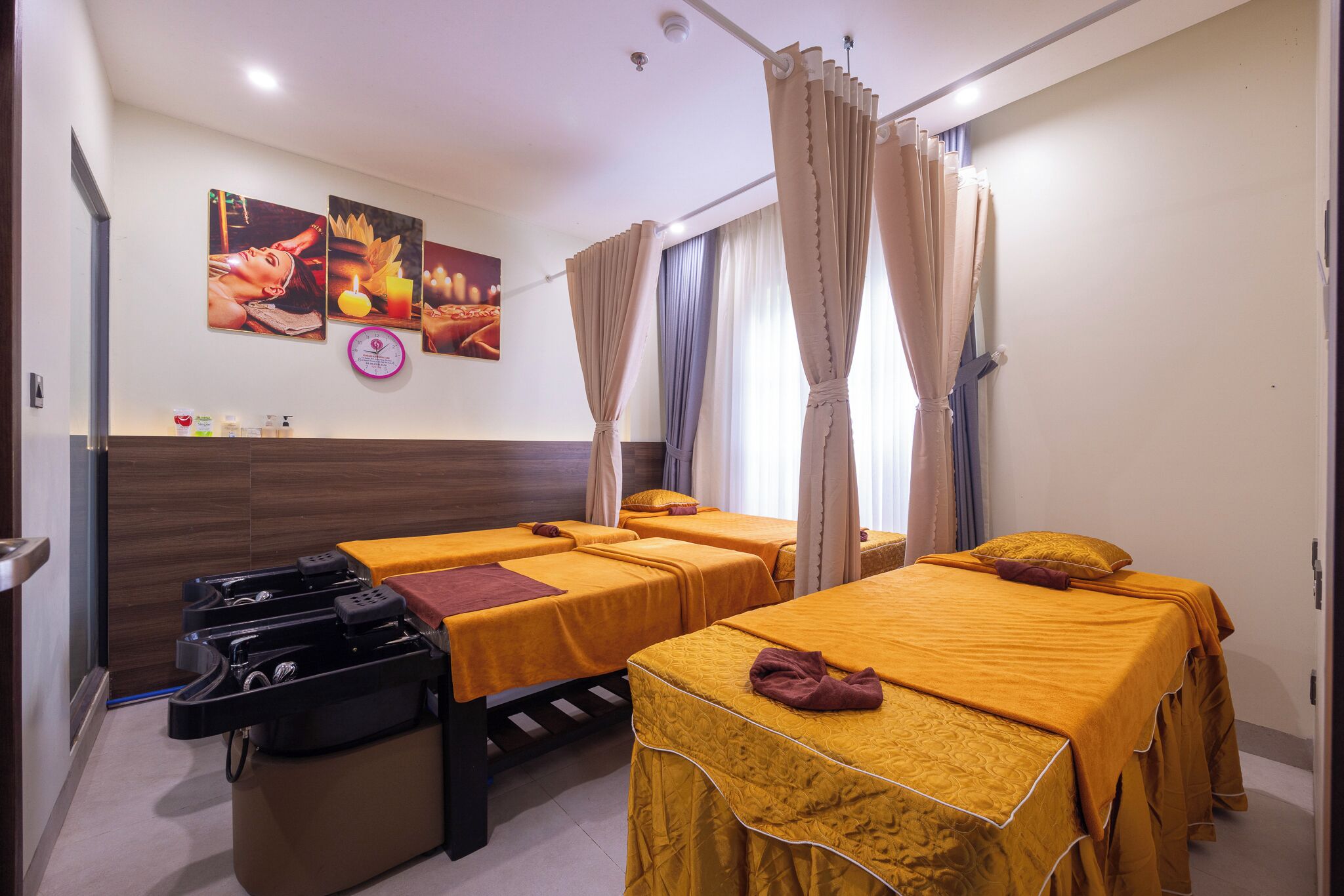 A hotel room with two single beds, a massage chair, and a wall-mounted massage table.