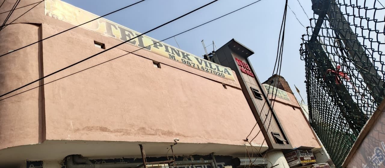 Um edifício com uma placa que diz "PINK VILLA" e um número de telefone.