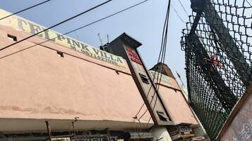 Um edifício com uma placa que diz "PINK VILLA" e um número de telefone.