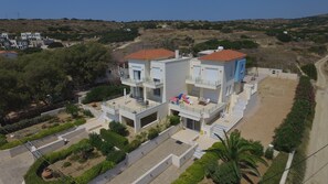A modern two-story residential building with a flat roof, a balcony, and a small garden area. - Entire home in Lilikas, Greece (Kalamoti)