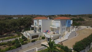 A modern two-story building with balconies, a patio area, and a view of the surrounding landscape. - Entire home in Lilikas, Greece (Kalamoti)