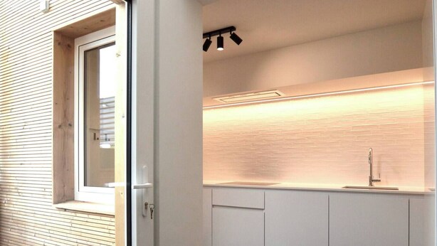 A modern kitchen with a skylight, white cabinets, and a dark floor. - Cozy, quiet apartment 200 meters from the sea with garage (Middelkerke)