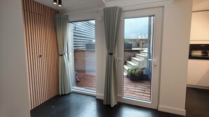A modern interior with a skylight, a sliding glass door leading to an outdoor area, and a built-in oven. - Cozy, quiet apartment 200 meters from the sea with garage (Middelkerke)