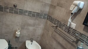 Et badeværelse med toilet, bidet og håndvask.