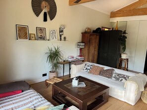 A cozy living room with a sofa, coffee table, and a bookshelf. - Wooden house on the Landaise Coast, 5 minutes from the ocean and lakes; ideal for families; pets allowed! (Biscarrosse)