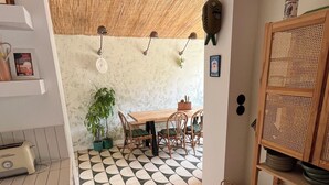 A kitchen with a dining area, featuring a wooden table, chairs, a potted plant, and a tiled floor. - Wooden house, côte landaise 5min ocean, lakes, ideal family, animals accepted! (Biscarrosse)