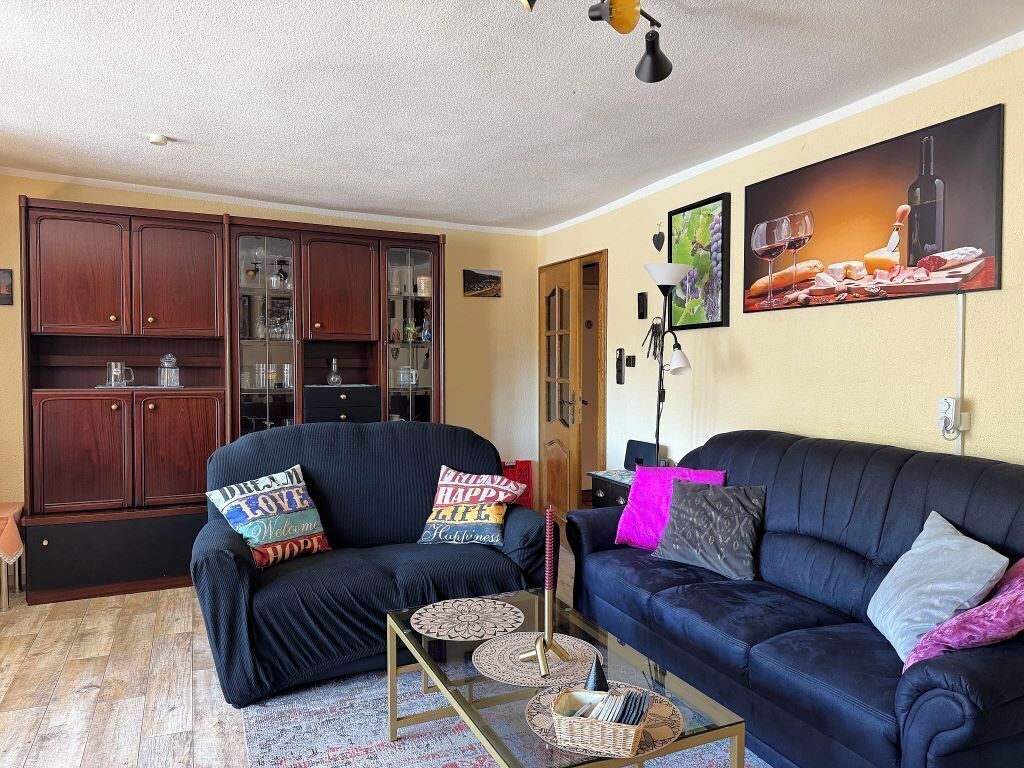 A living room with two sofas, a coffee table, and a cabinet.