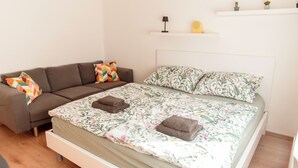Ein Schlafzimmer mit einem Bett, einem Schlafsofa und einem Nachttisch.