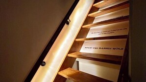 A wooden staircase with illuminated handrails and steps, each with a motivational quote. - Wonderland21 (Saint-Germain-sur-Morin)