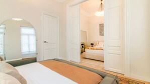 Una camera da letto con un letto, un armadio e una porta aperta che dà su un bagno.