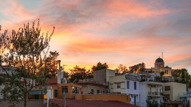 Una terrazza sul tetto con pavimento a scacchi, un divano e un vaso di fiori.