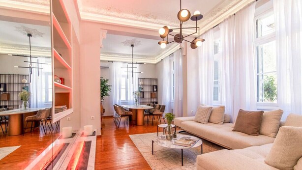 Ein geräumiges Wohnzimmer mit einer Couch, einem Couchtisch und einem Essbereich mit Stühlen und einem Tisch.
