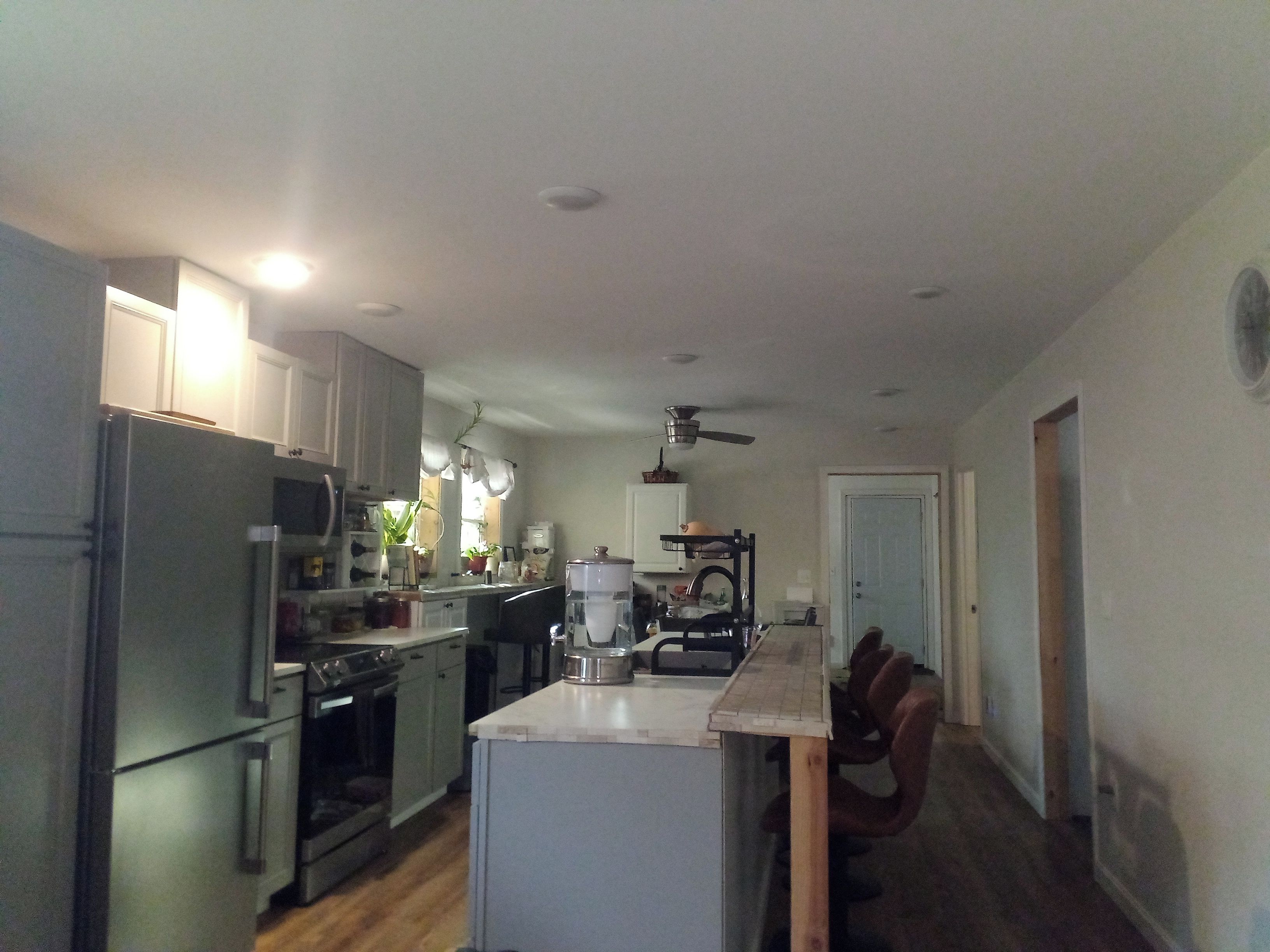 A kitchen with a refrigerator, oven, microwave, and a coffee maker.