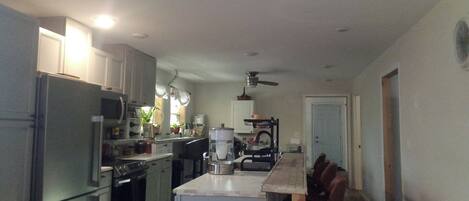 A kitchen with a refrigerator, oven, microwave, and a coffee maker.