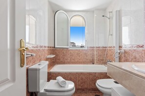 A modern bathroom with a bathtub, two toilets, a shower, and a vanity with a mirror. - Lovely 2-bed 10 Mins Walk From Puerto Banus (Marbella)