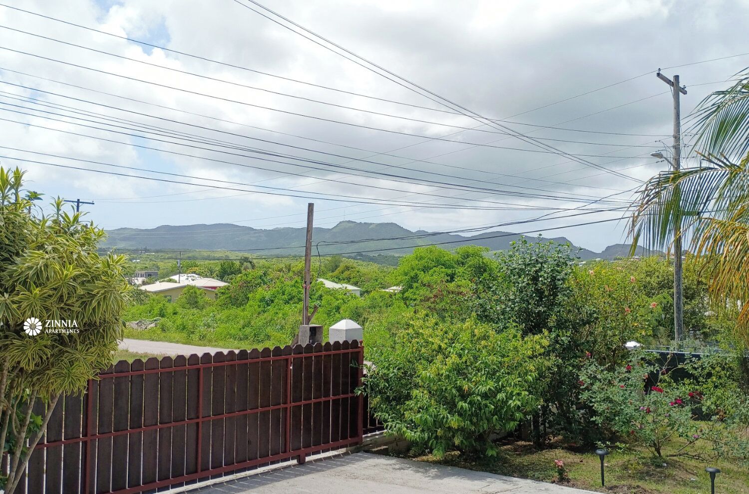 Área residencial murada com vista para montanhas distantes e vegetação.