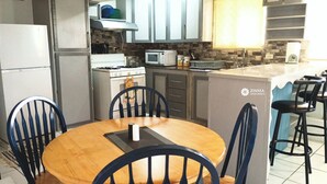 Une cuisine avec un coin repas, comprenant une cuisinière, un four à micro-ondes et des placards.