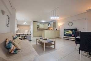 Apartamento familiar, balcón | Zona de estar | Una televisión de pantalla plana